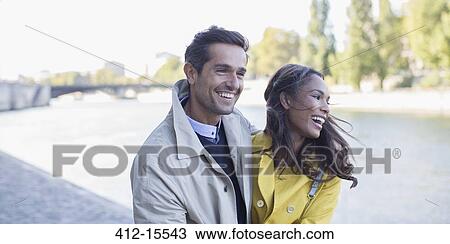 Stock Image - Couple walking along Seine River, Paris, France. Fotosearch