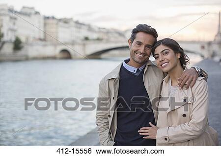 Stock Photograph - Couple walking along Seine River, Paris, France. Fotosearch