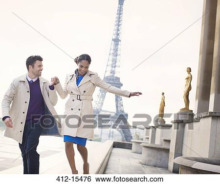 Couple walking in front of Eiffel Tower, Paris, France View Large Photo Image Stock Photograph - Couple walking in front of Eiffel Tower, Paris, France. Fotosearch