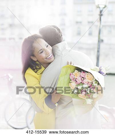 Couple with bouquet of flowers hugging along Seine River, Paris, France View Large Photo Image Stock Photo - Couple with bouquet of flowers hugging along Seine River, Paris, France. Fotosearch