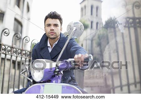 Stock Photo - Man driving scooter on city street. Fotosearch