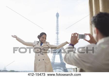 Man photographing girlfriend in front of the Eiffel Tower, Paris, France View Large Photo Image Stock Image - Man photographing girlfriend in front of the Eiffel Tower, Paris, France. Fotosearch