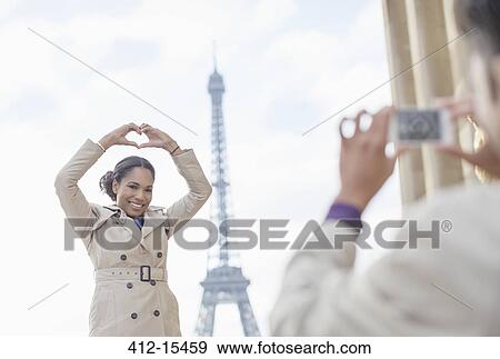 Man photographing girlfriend in front of Eiffel Tower, Paris, France View Large Photo Image Stock Photo - Man photographing girlfriend in front of Eiffel Tower, Paris, France. Fotosearch