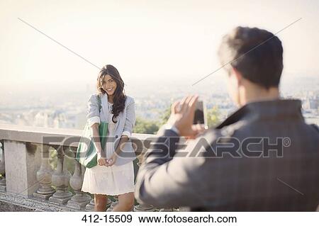 Man photographing girlfriend with Paris in background View Large Photo Image Stock Photo - Man photographing girlfriend with Paris in background. Fotosearch