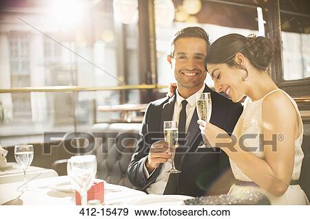 Well-dressed couple drinking champagne in restaurant View Large Photo Image Stock Photo - Well-dressed couple drinking champagne in restaurant. Fotosearch