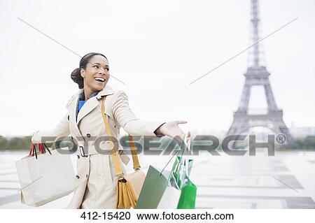 Woman carrying shopping bags by Eiffel Tower, Paris, France View Large Photo Image Stock Image - Woman carrying shopping bags by Eiffel Tower, Paris, France. Fotosearch
