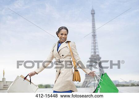 Woman carrying shopping bags by Eiffel Tower, Paris, France View Large Photo Image Stock Photo - Woman carrying shopping bags by Eiffel Tower, Paris, France. Fotosearch