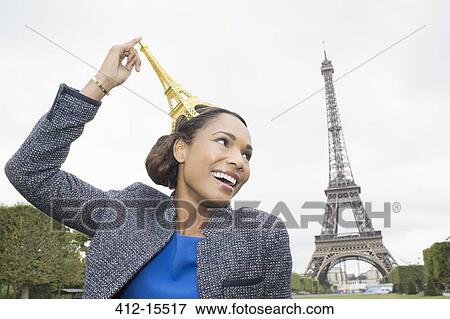 Stock Photo - Woman posing with souvenir in front of Eiffel Tower, Paris, France. Fotosearch