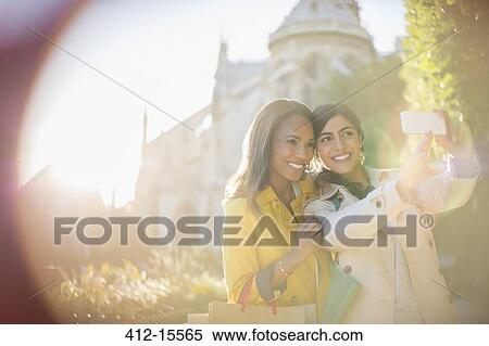 Stock Photography - Women taking self-portrait in urban park. Fotosearch