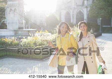 Stock Image - Women walking in urban park. Fotosearch