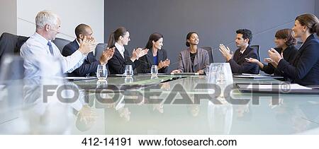 Stock Image - Business people applauding colleague in meeting. Fotosearch