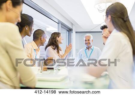 Stock Photo - Business people clapping in meeting. Fotosearch