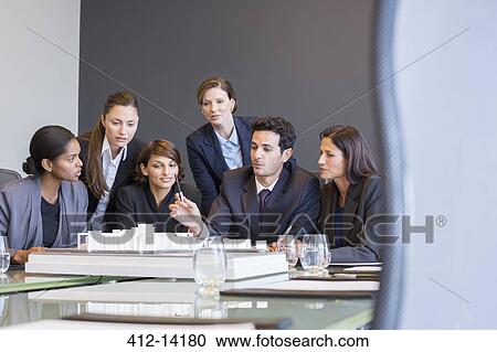 Business people examining model in meeting View Large Photo Image Stock Image - Business people examining model in meeting. Fotosearch