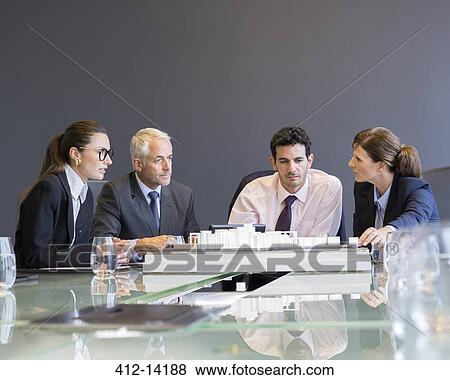 Stock Photo - Business people looking at architectural model in office. Fotosearch