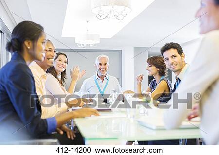 Stock Image - Business people sitting in meeting. Fotosearch