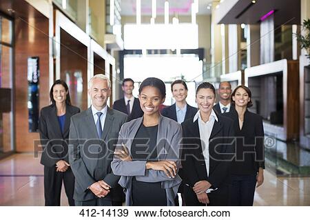 Stock Photo - Business people smiling in lobby. Fotosearch