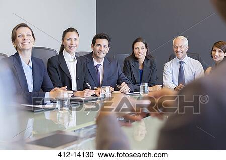 Stock Image - Business people smiling in meeting. Fotosearch