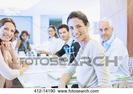 Stock Image - Business people smiling in meeting. Fotosearch