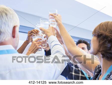 Stock Photography - Business people toasting water glasses. Fotosearch