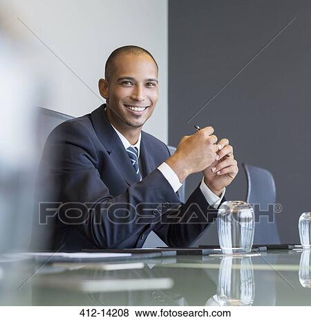 Businessman smiling in meeting View Large Photo Image Stock Photo - Businessman smiling in meeting. Fotosearch