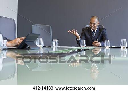 Stock Image - Businessman talking in meeting. Fotosearch