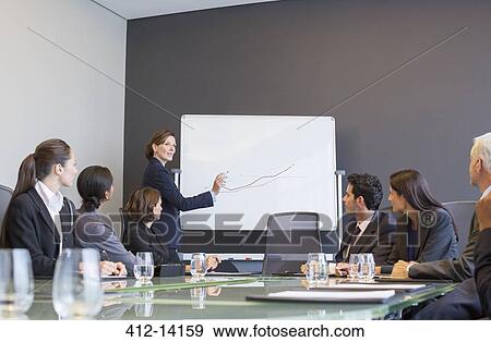 Businesswoman drawing graph for colleagues in meeting View Large Photo Image Stock Photo - Businesswoman drawing graph for colleagues in meeting. Fotosearch