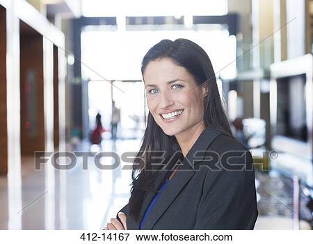 Stock Photo - Businesswoman smiling in lobby. Fotosearch