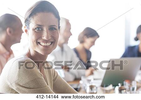 Businesswoman smiling in meeting View Large Photo Image Picture - Businesswoman smiling in meeting. Fotosearch