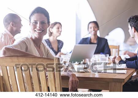 Stock Image - Businesswoman smiling in meeting. Fotosearch