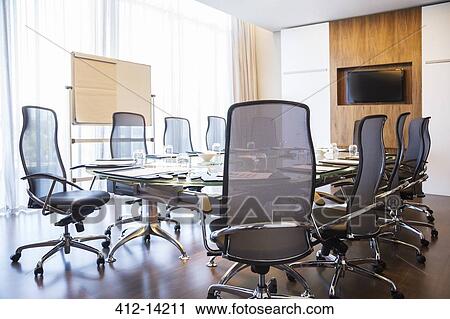 Stock Image - Chairs and table in empty meeting room. Fotosearch