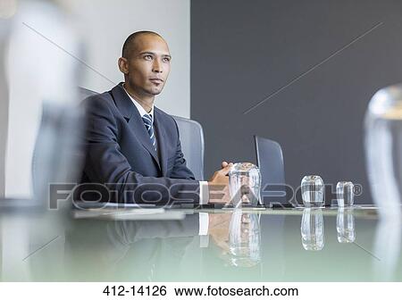 Pensive businessman sitting in meeting View Large Photo Image Stock Photograph - Pensive businessman sitting in meeting. Fotosearch