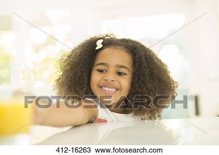 Girl reaching for glass of orange juice View Large Photo Image Stock Image - Girl reaching for glass of orange juice. Fotosearch