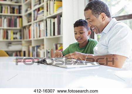 Grandfather and grandson reading book View Large Photo Image Stock Photo - Grandfather and grandson reading book. Fotosearch