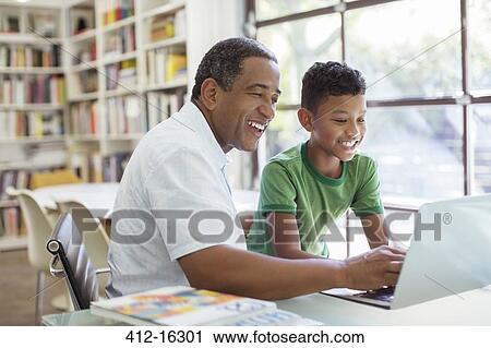 Stock Image - Grandfather and grandson using laptop. Fotosearch