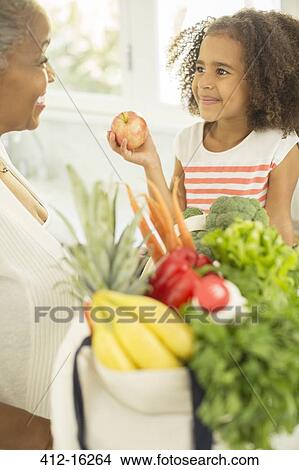 Grandmother and granddaughter unpacking groceries View Large Photo Image Picture - Grandmother and granddaughter unpacking groceries. Fotosearch
