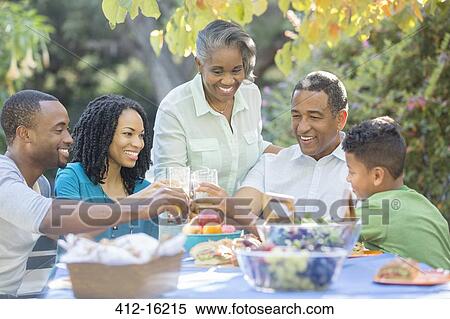 Happy family eating lunch at patio table View Large Photo Image Stock Photography - Happy family eating lunch at patio table. Fotosearch