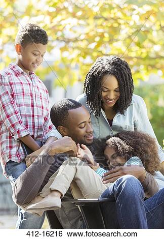 Happy family hugging outdoors View Large Photo Image Stock Photograph - Happy family hugging outdoors. Fotosearch
