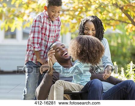 Stock Image - Happy family laughing outdoors. Fotosearch