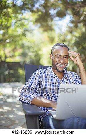 Happy man using laptop outdoors View Large Photo Image Stock Photograph - Happy man using laptop outdoors. Fotosearch