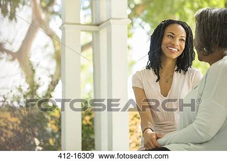 Happy mother and daughter talking on porch View Large Photo Image Stock Photo - Happy mother and daughter talking on porch. Fotosearch