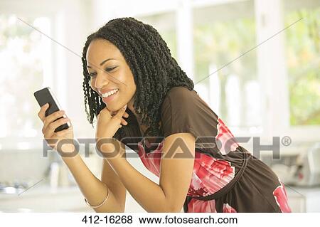 Happy woman text messaging with cell phone View Large Photo Image Stock Photo - Happy woman text messaging with cell phone. Fotosearch