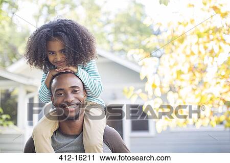 Portrait of happy father carrying daughter on shoulders View Large Photo Image Stock Image - Portrait of happy father carrying daughter on shoulders. Fotosearch