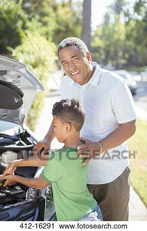 Portrait of smiling grandfather working on car engine with grandson View Large Photo Image Stock Image - Portrait of smiling grandfather working on car engine with grandson. Fotosearch