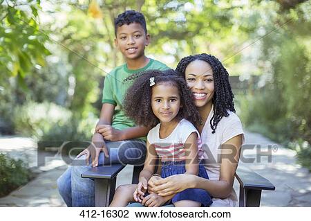 Stock Image - Portrait of smiling mother and children outdoors. Fotosearch