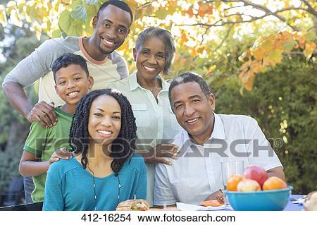 Picture - Portrait of smiling multi-generation family at patio table. Fotosearch