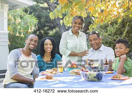 Portrait of smiling multi-generation family eating lunch on patio View Large Photo Image Stock Image - Portrait of smiling multi-generation family eating lunch on patio. Fotosearch