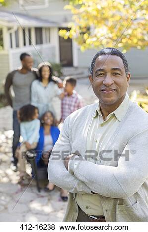 Portrait of smiling senior man with multi-generation family in background View Large Photo Image Stock Photo - Portrait of smiling senior man with multi-generation family in background. Fotosearch