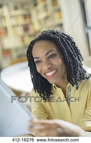 Stock Photograph - Smiling woman using digital tablet. Fotosearch