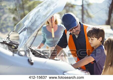 Stock Photo - Boy watching roadside mechanic check car engine. Fotosearch
