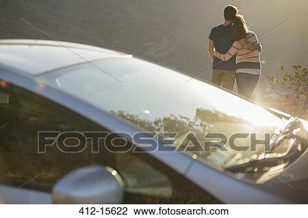 Couple hugging outside car at roadside View Large Photo Image Stock Image - Couple hugging outside car at roadside. Fotosearch